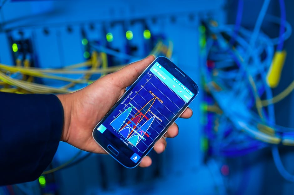 Ruka drži pametni telefon koji prikazuje mrežnu analizu u okruženju servera
